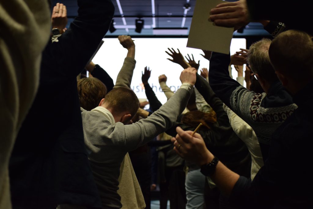 publik som har händer och block upp i luften